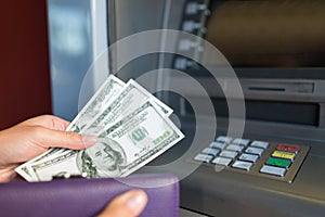 Close up of hand withdrawing money at atm machine photo