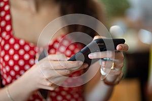 Close up hand of woman concept play with smart phone in cafe wood table background