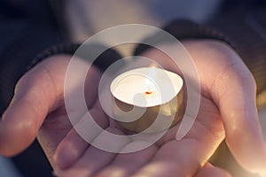 Close up hand of woman holdiClose up hand of woman holding lighting candles in the palm at theng lighting candles in the plam at t