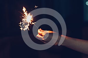 Close up hand woman holding sparklers in night party and christmas celebration