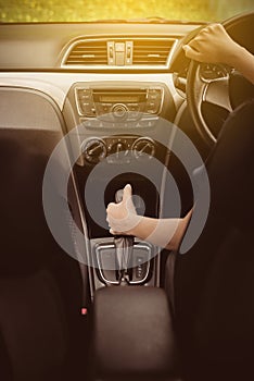 Close up of hand woman holding steering wheel and on automatic gear shift ,Driving a car