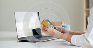 Close up hand of woman making card payment through mobile phone to pay bills