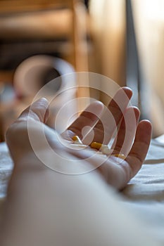 Close up hand of woman overdosing on medication.