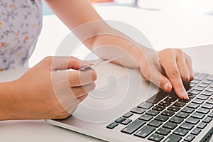 Close up hand of woman using laptop computer and holding credit card for online shopping