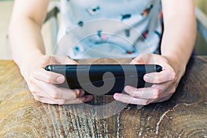 Close up hand woman using smartphone in coffee shop