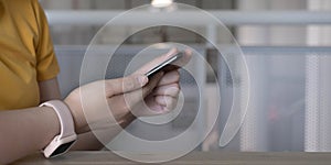 Close up hand of woman using smartphone at coffee shop cafe