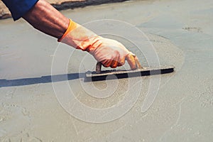 close up hand worker leveling concrete pavement for mix cement a