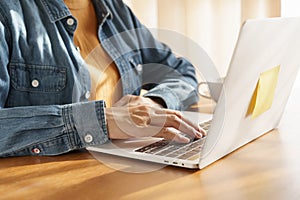 Close-up hand working women using keyboard on laptop at hom, Warm morning sunlight photo