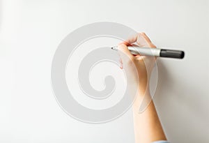 Close up of hand writing something on white board