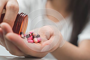 Close up hand of young asian woman taking medicine overdose trying to kill herself, Sick woman take a