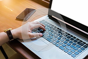 close up hand young business man using laptop and mouse on wooden desk in office.