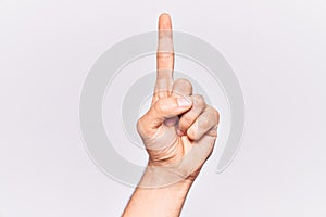 Close up of hand of young caucasian man over isolated background counting number one using index finger, showing idea and