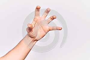 Close up of hand of young caucasian man over isolated background grasping aggressive and scary with fingers, violence and