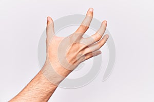 Close up of hand of young caucasian man over isolated background grasping aggressive and scary with fingers, violence and