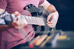 Close up hand of young man playing on a professional, black electric guitar, music instrument, entertainment, lifestyle