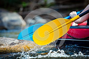 Close-up hand of young person is rafting on the river