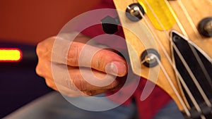 Close up of handement of man tuning his guitar