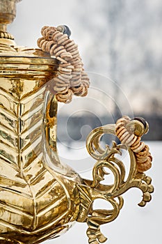 Close-up handle. Large metal gold old traditional Russian samovar for tea drinking.