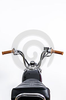 Close up of handlebar and fuel tank on vintage motorcycle. Custom scrambler / chopper. Retro motorbike on white background. Blank photo