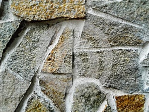 Close-up  of handmade  cracked multicolored  stone and concrete  wall