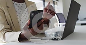 Close up of hands of african american businesswoman using smartphone