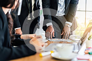 Close-up hands of African businessman planning and discuss with Caucasian colleagues that looking on documents.