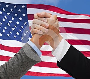 Close up of hands armwrestling over american flag