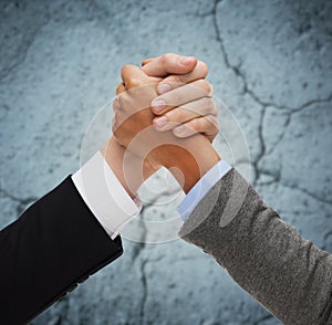 Close up of hands armwrestling over concrete wall