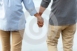 Close up hands.  Asian Lifestyle senior couple hand in hand and walking chill on the beach happy