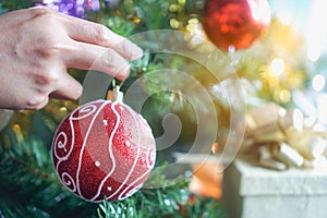 Close-up hands of asian women decorating green ball on christmas tree for prepare xmas party