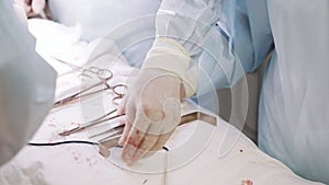 Close up hands of assistant, doctor hands use medical instruments during surgery, clamp, cotton swab