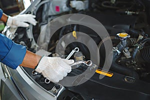 Close up hands of auto mechanic doing car service and maintenance