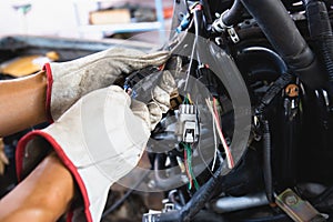 Close up hands of auto mechanic doing car service and maintenance. Car wiring with adapters and connectors changing