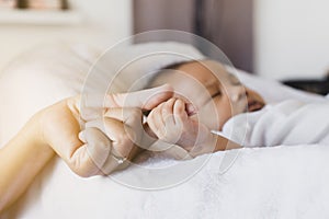 Close up of hands baby newborn holding mom finger,Family love concept