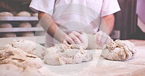 close-up on hands of baker kneading dough to bake fresh bread