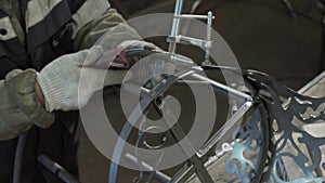 Close-up - Hands Of A Blacksmith Weld Elements To Their Forged Product