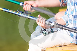 Close-up of hands of a boy with a fishing rod