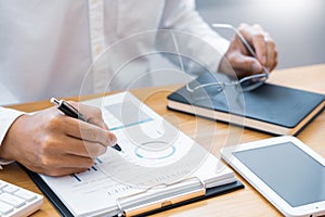 Close-up of hands Businessman reading and writing with pen signing contract over document for Completing Application Form at work