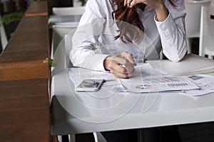 Close up hands of businesswoman holding crumple paperwork at the desk in office. Stressed business concept.