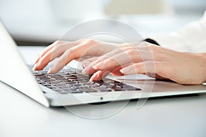Close-up of hands of businesswoman typing on a laptop