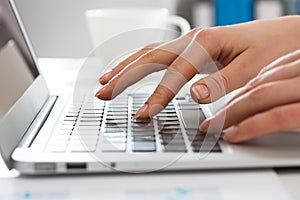 Close-up of hands of businesswoman typing on a laptop