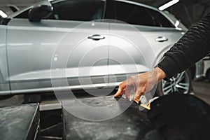 Close up of hands of car mechanic in auto repair service