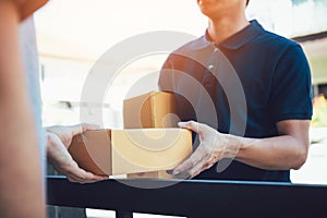 Close up of hands cargo staff are delivering cardboard boxes with parcels inside to the recipient`s hand