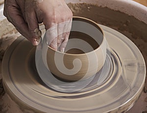 Close-up of the hands of a ceramist working in his potter wheel