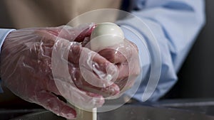 Close up for hands of a cheesemaker cutting mozzarella with hands, traditional food concept. Frame. Process of making