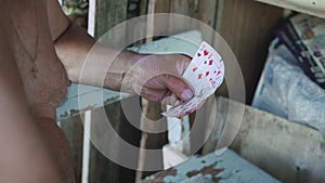 Close-up of the hands and chest of an old man with bare torso, who playing cards