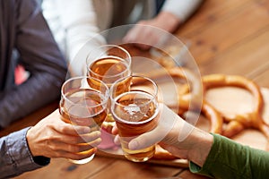 Close up of hands clinking beer at bar or pub