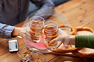 Close up of hands clinking beer at bar or pub