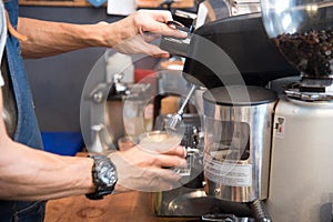 Close up hands coffee barista man make hot cup espresso shot from coffee machine. Cappuccino with milk in italian coffee shop cafe