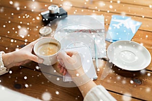 Close up of hands with coffee cup and travel stuff